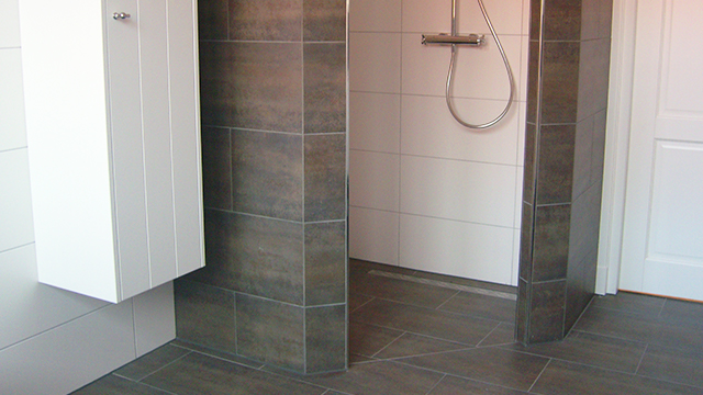 Moderne badkamer met grote tegels en wit badkamermeubel