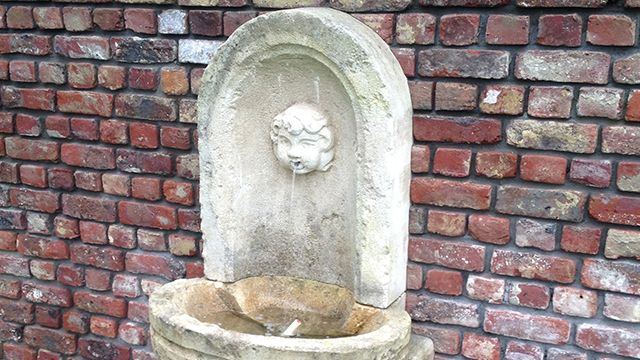 De antieke witte fontein met een gezicht er in